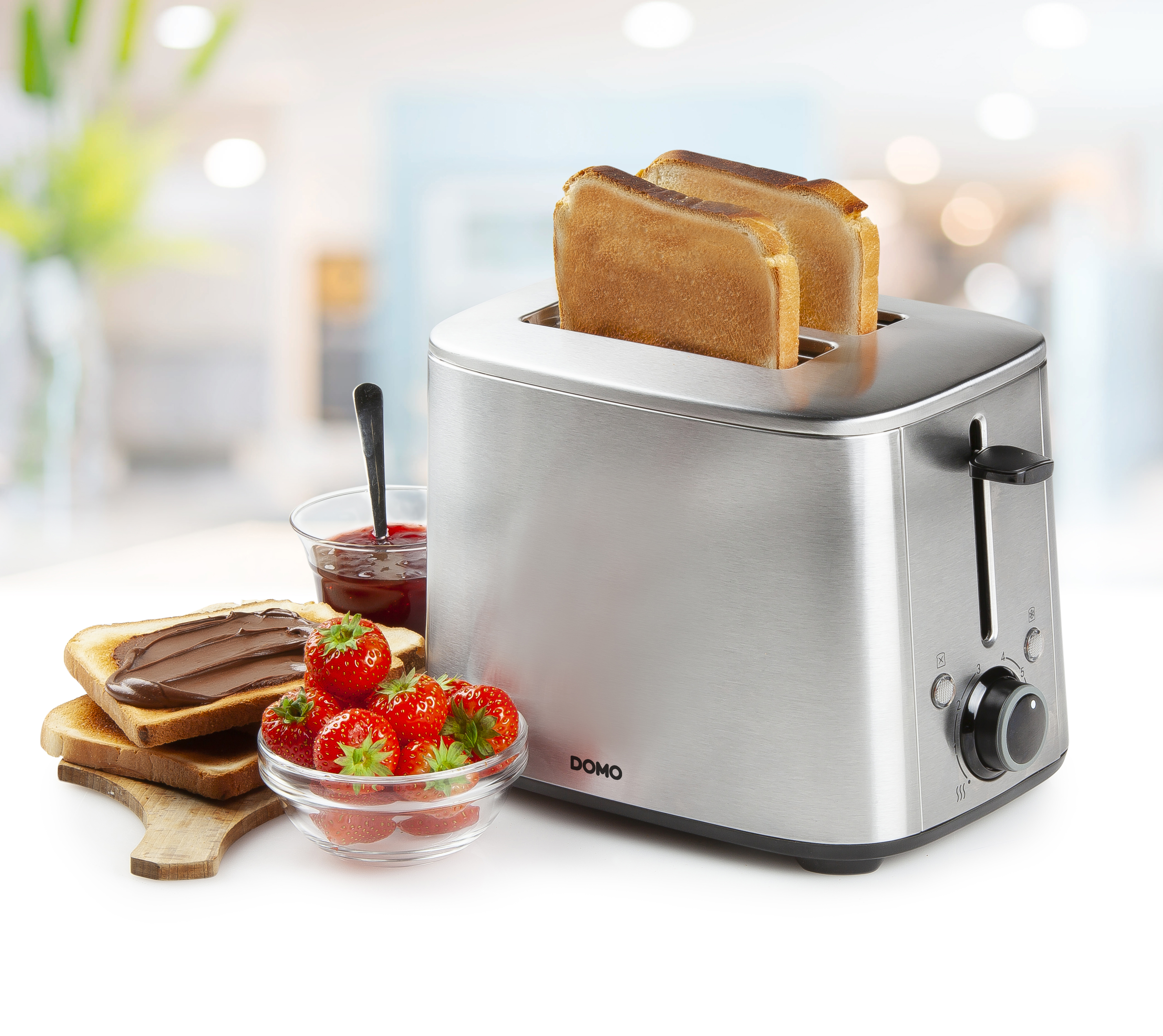 Toaster with toast, jam, strawberries, and chocolate spread. Blurred background of a kitchen.