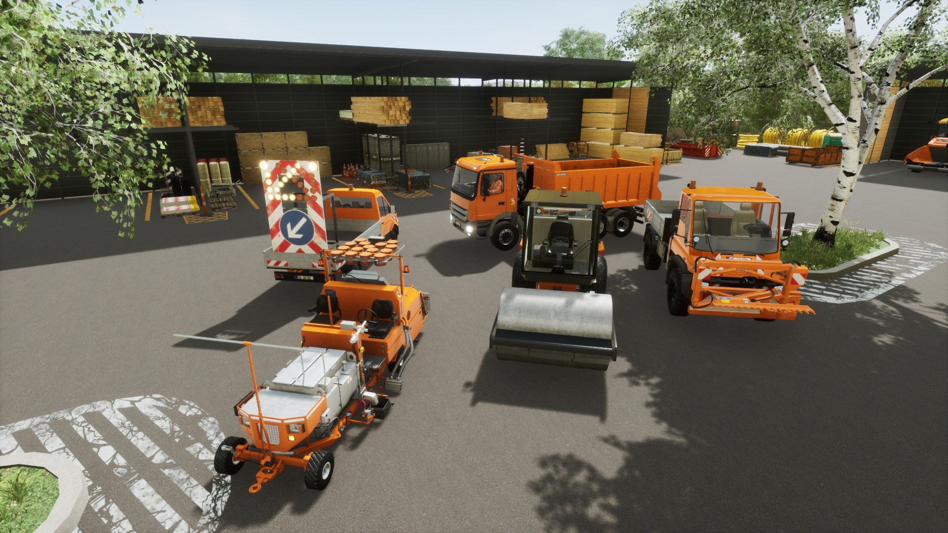 Veicoli arancioni per lavori stradali parcheggiati sull'asfalto. Un cartello con freccia di sicurezza sullo sfondo.