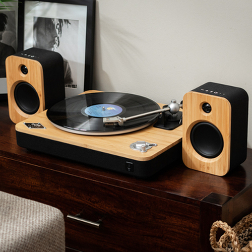 Houten platenspeler met twee luidsprekers. Vinylplaat op de platenspeler. Donkerbruin meubilair.