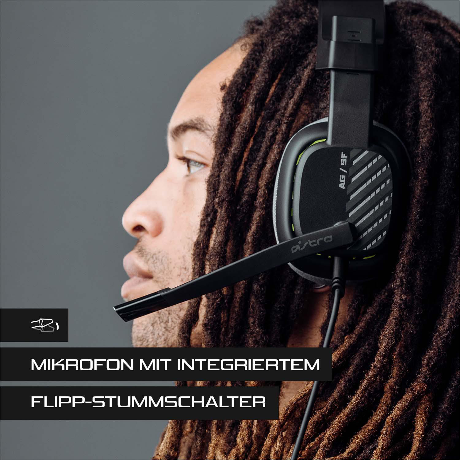 Mann mit schwarzem und grünem Gaming-Headset. Text auf dem Headset. Grauer Hintergrund.