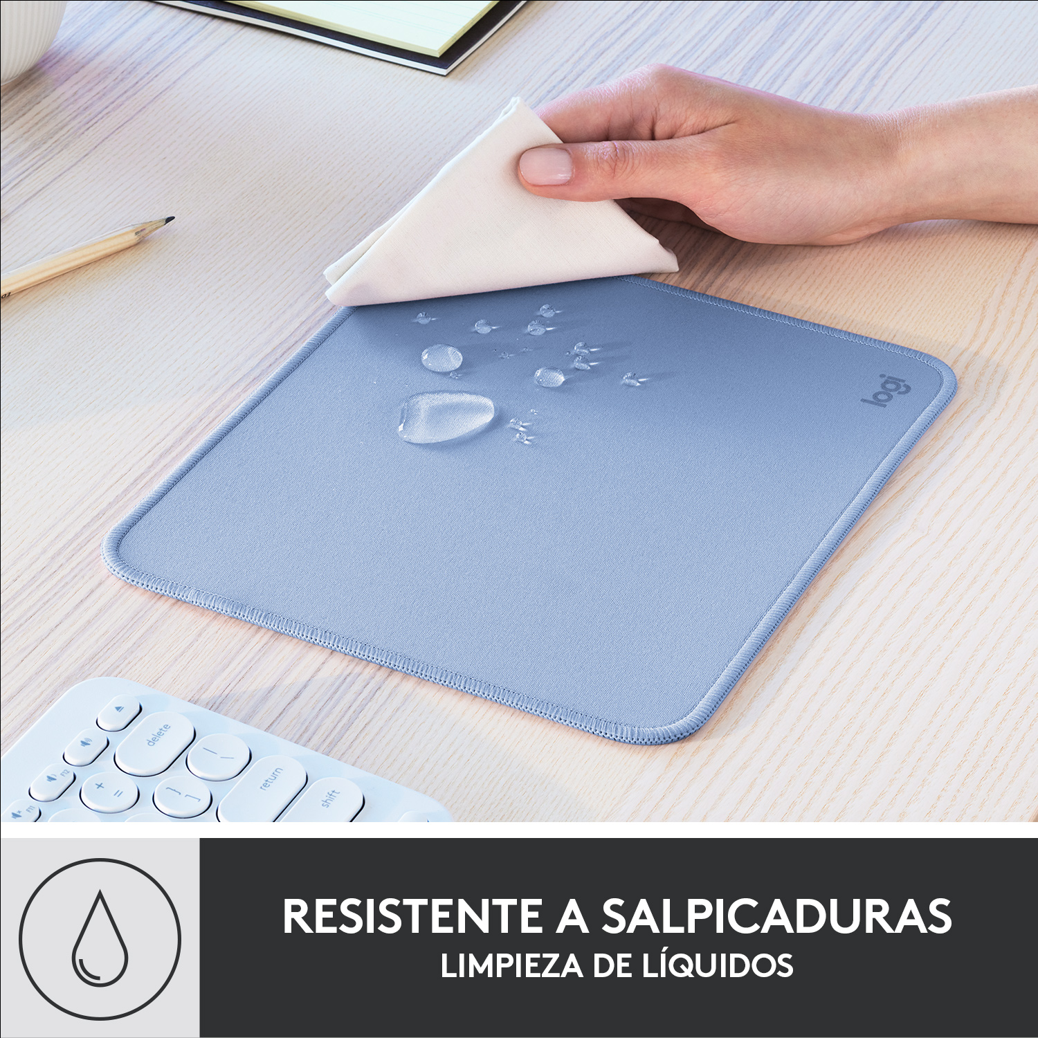 Una alfombrilla azul con gotas de agua y un paño blanco. Un teclado está en la esquina inferior izquierda.