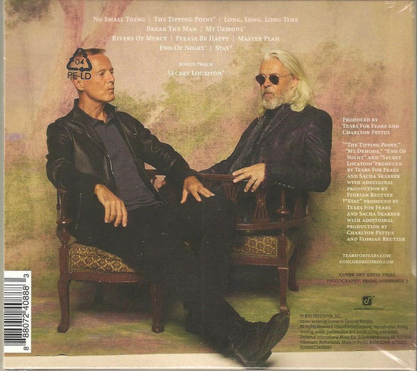 CD-Cover mit zwei Männern, die sitzen und reden. Text ist auf dem Cover sichtbar. Der Hintergrund ist braun.