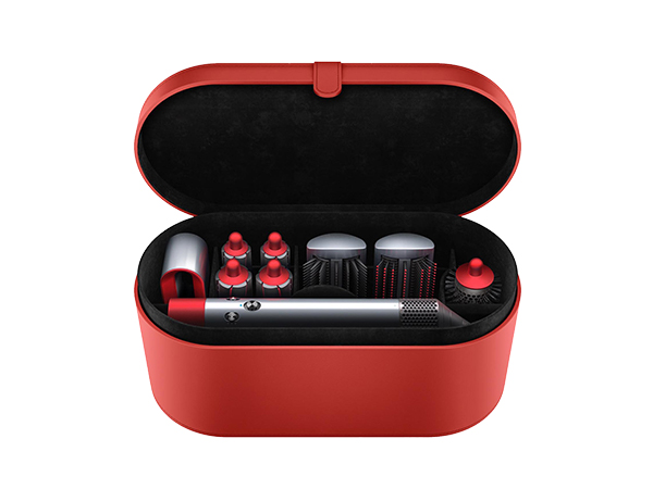 Rode koffer met haarstylingtools. Zilveren handvat en rode accessoires.