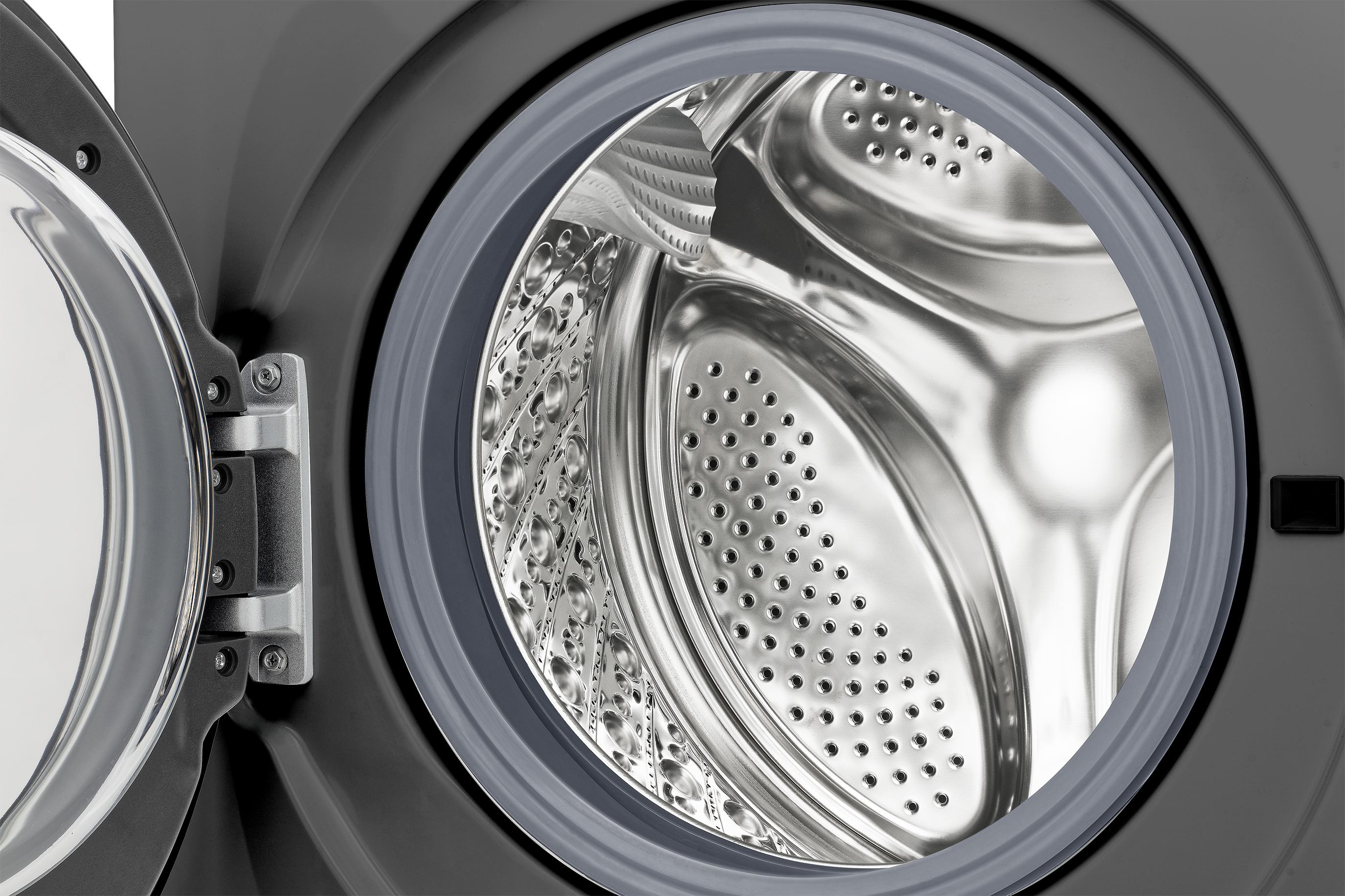 Gros plan sur le tambour d'une machine à laver avec porte ouverte, extérieur gris.