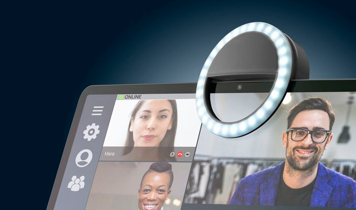 Une lumière annulaire sur un ordinateur portable, avec un appel vidéo montrant trois personnes. C'est un fond bleu foncé.