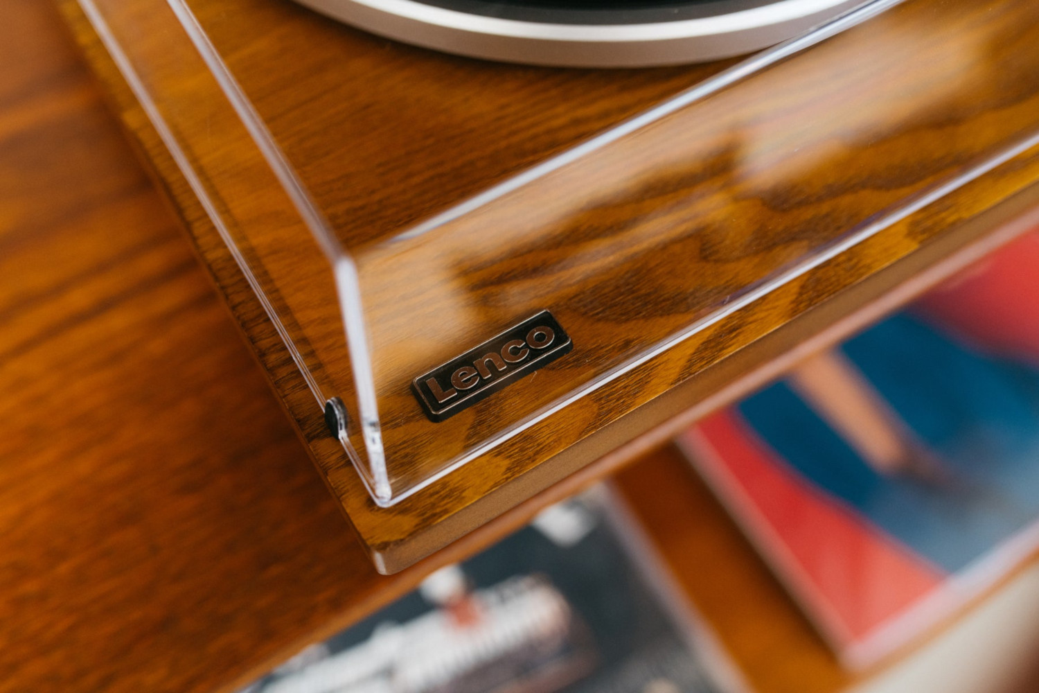 Gros plan d'une platine vinyle en bois avec le logo Lenco, sur une surface en bois.