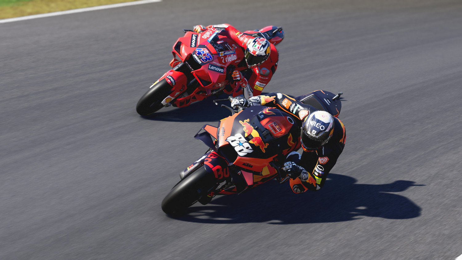 Deux motos en course sur une piste. L'une est rouge, l'autre noire et orange. Le fond est flou.