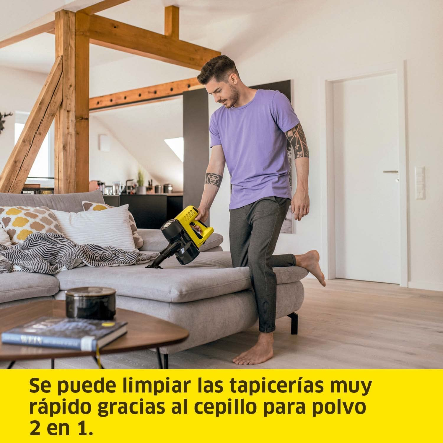 Un hombre aspira un sofá en un salón.