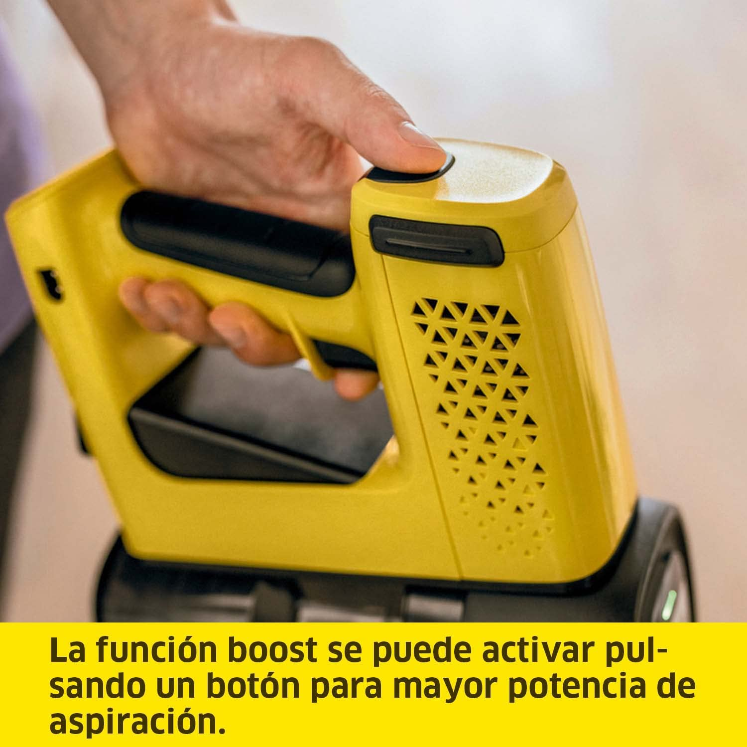 Una mano presiona un botón en una aspiradora amarilla. El texto dice que la función de impulso se puede activar.