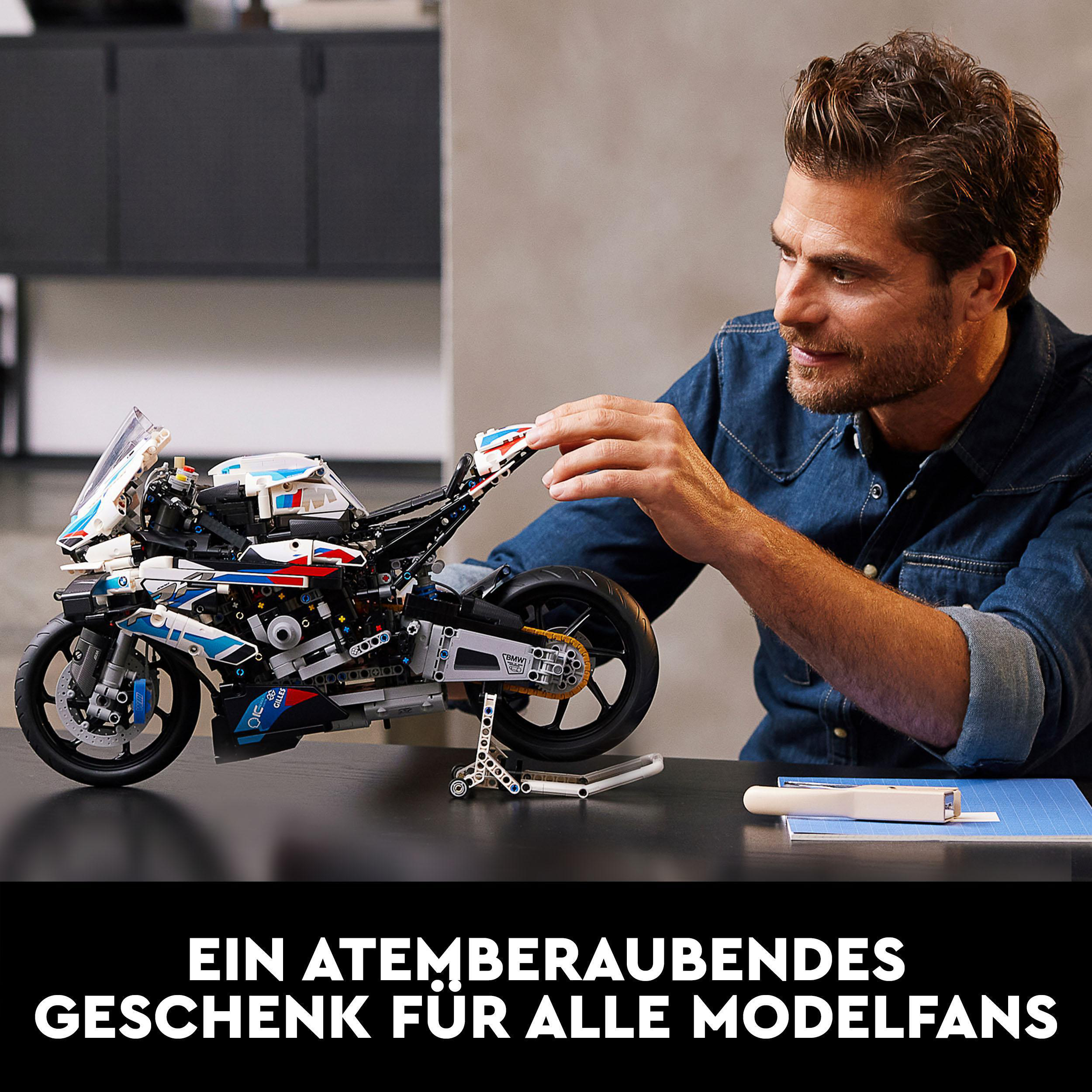 Mann baut Motorrad-Modellbausatz. Motorrad ist schwarz, weiß und blau. Text unten.