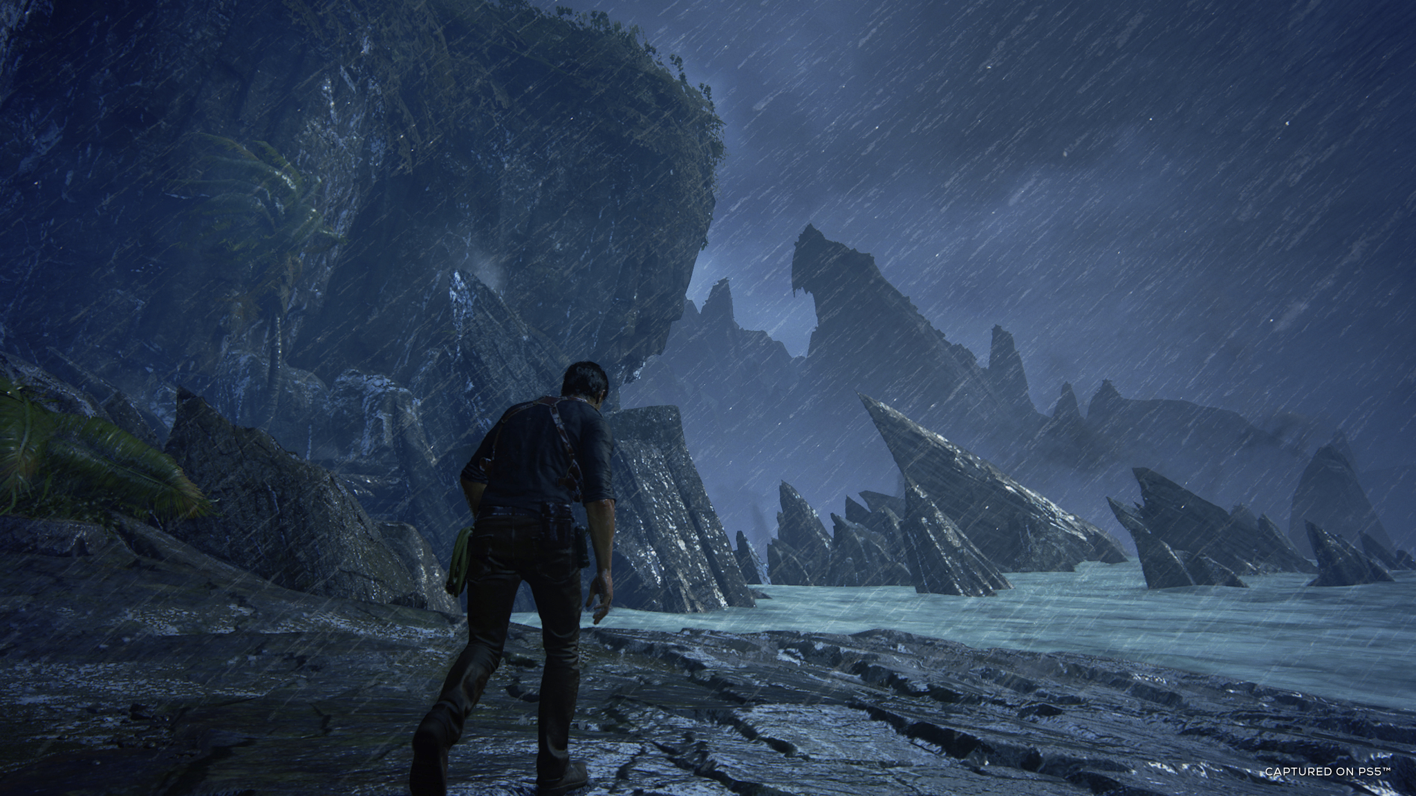 Man walks on a beach, rain, cliffs, dark environment.