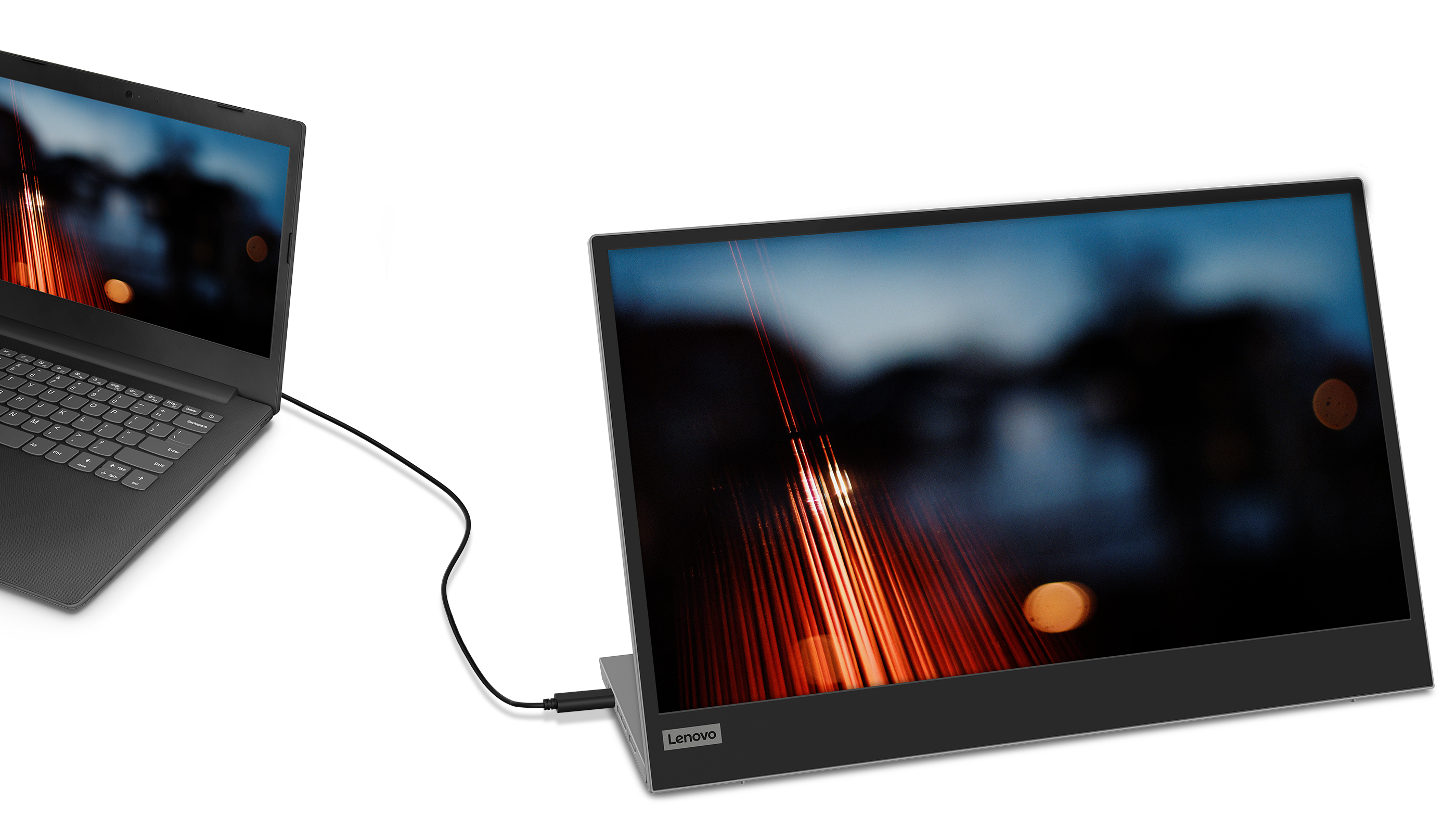 A laptop connected to a second monitor. The monitor displays an image with blurred red and orange lights.