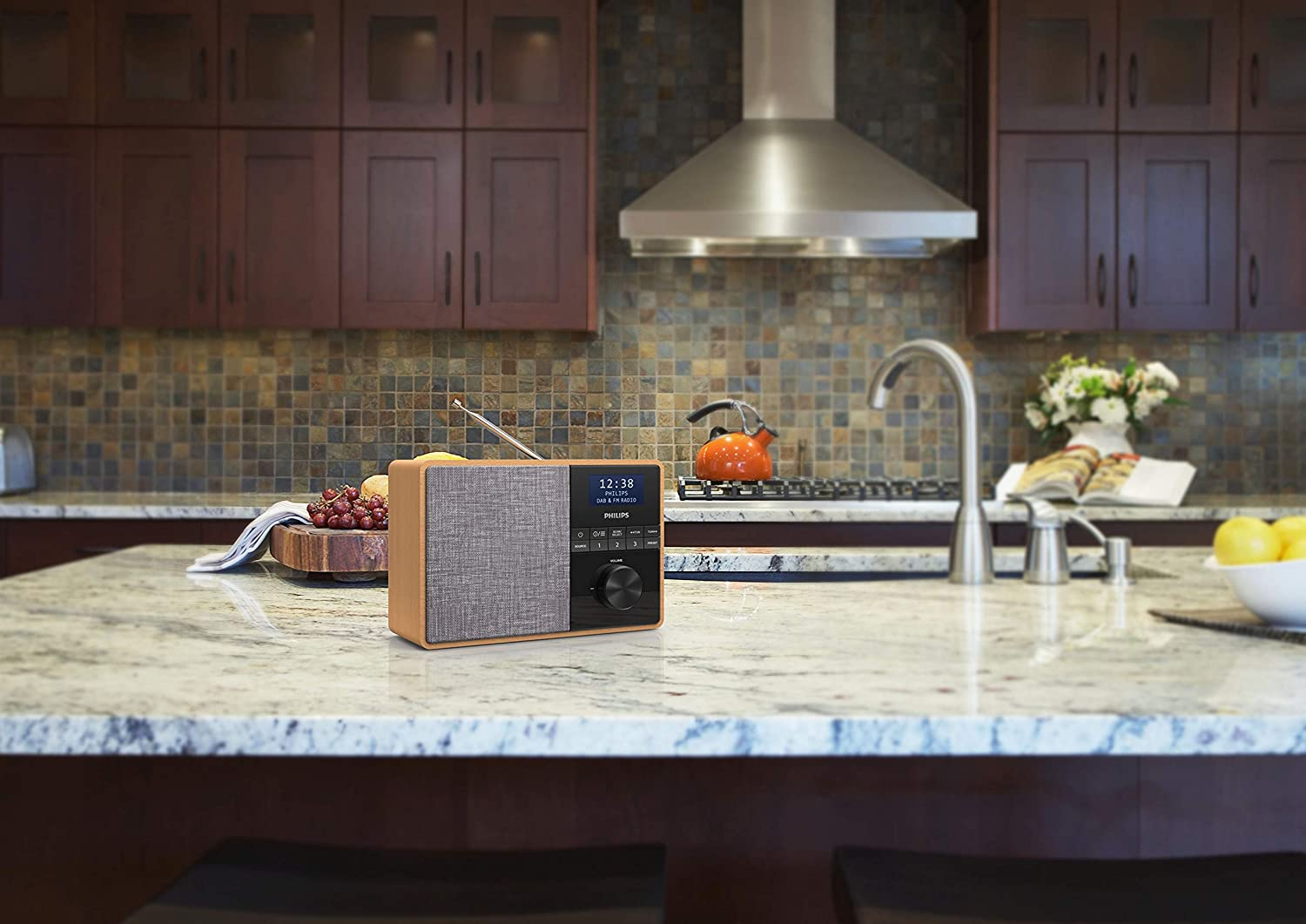 A wooden radio on a kitchen counter. Kitchen with brown cabinets in the background.