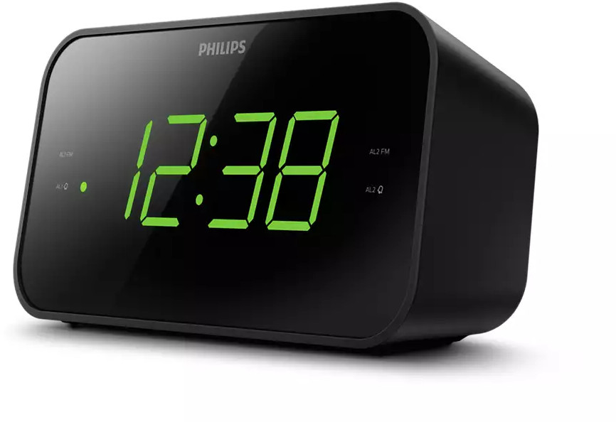 Réveil numérique noir avec des chiffres verts affichant 12:38. L'horloge est sur une surface.