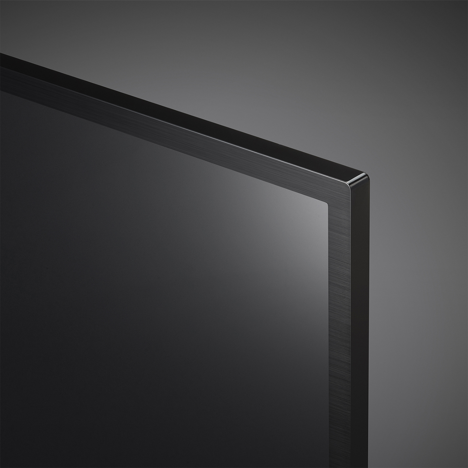 Primo piano dell'angolo di uno schermo TV nero con sfondo grigio scuro.