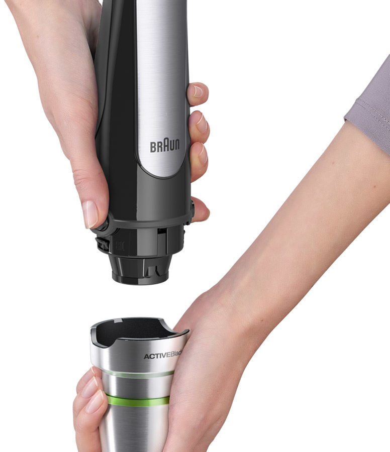 Hands assembling a black and silver Braun ActiveBlade hand blender. The blender is being attached.