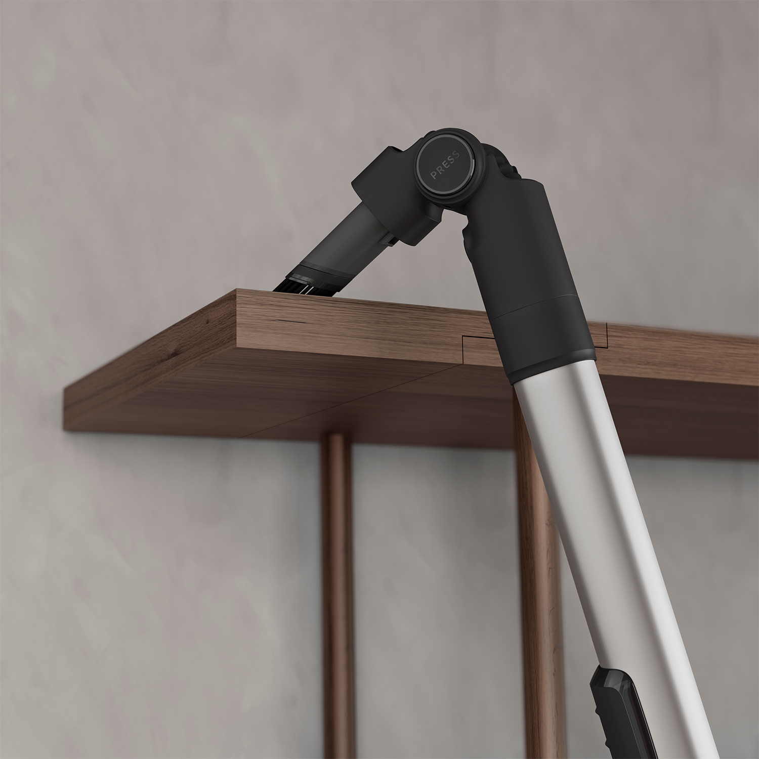Un accessorio per aspirapolvere pulisce il bordo di uno scaffale, focus sull'ugello e il bordo.