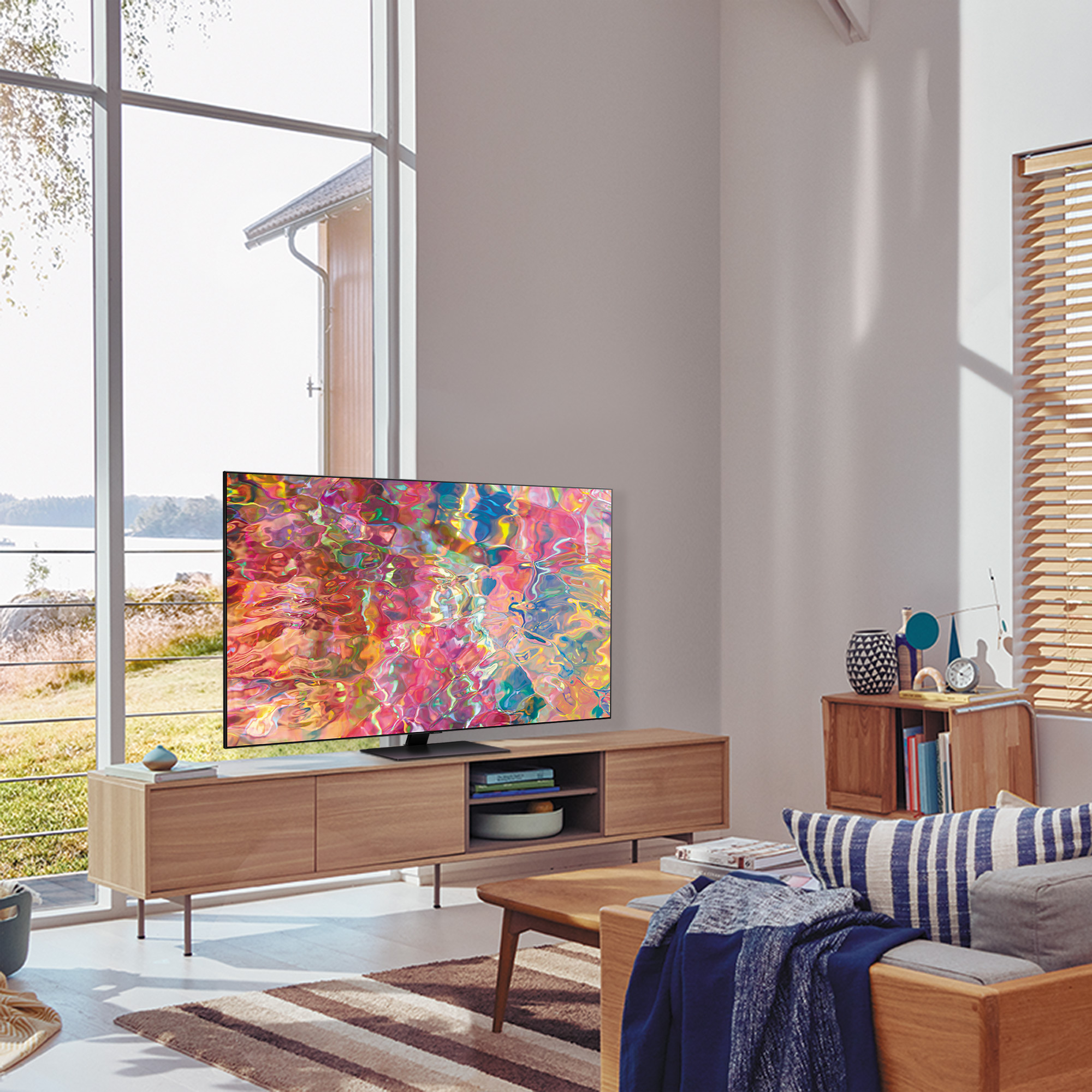 Un salón moderno con un televisor grande y muebles de madera. La pantalla del televisor muestra una imagen colorida.
