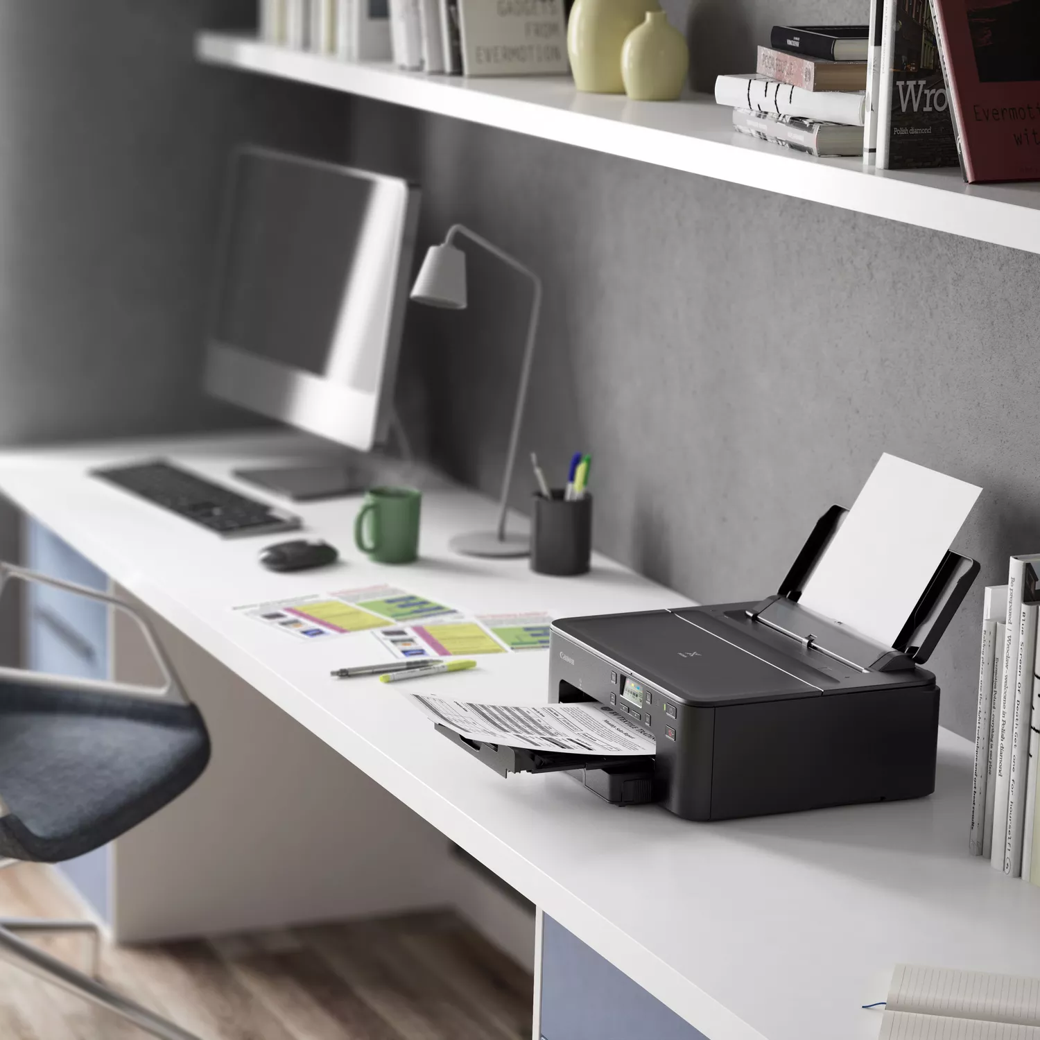 Ein Schreibtisch mit Computer, Lampe und Drucker.