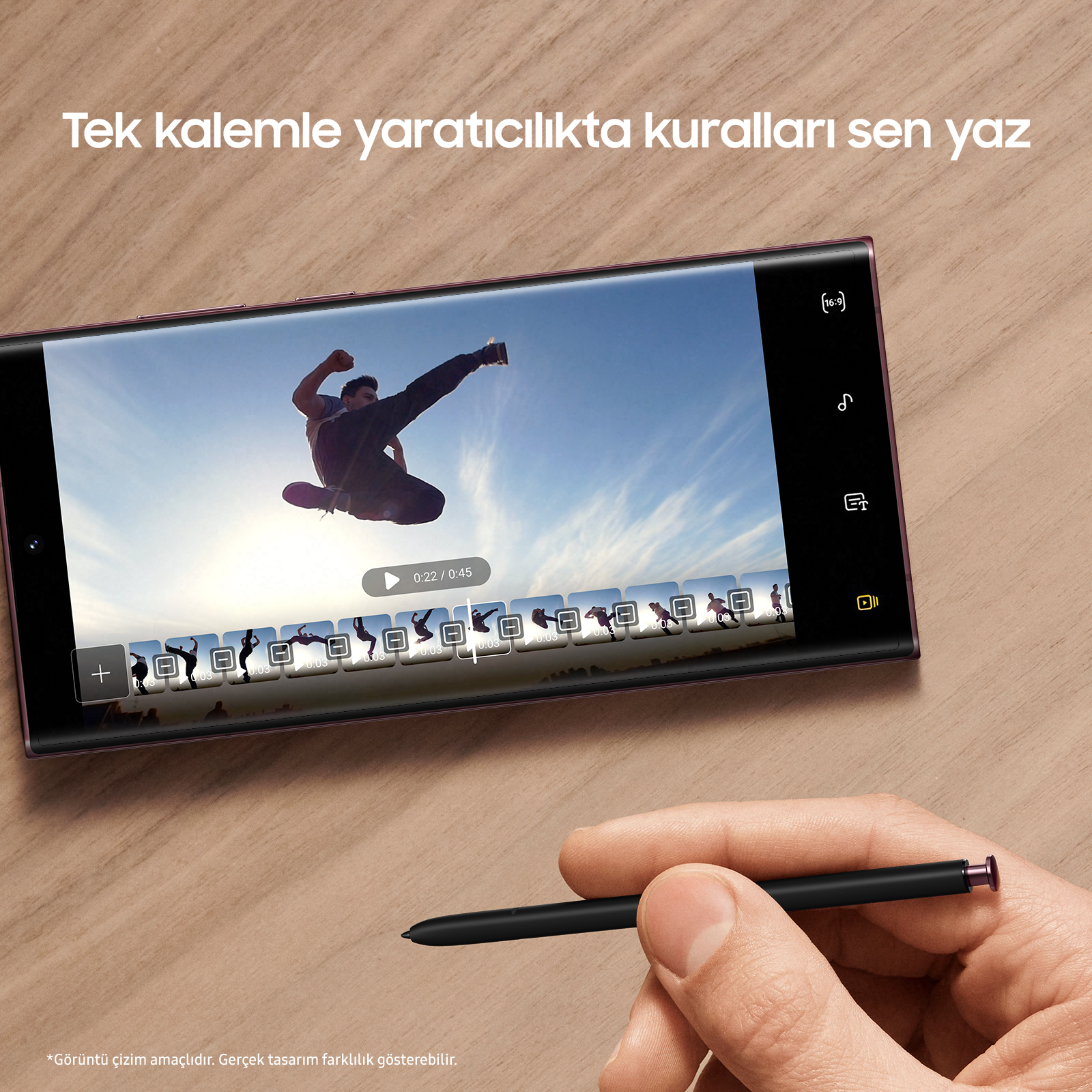 Bir kişi, bir kalemle bir telefon tutuyor, video gösteriliyor.
