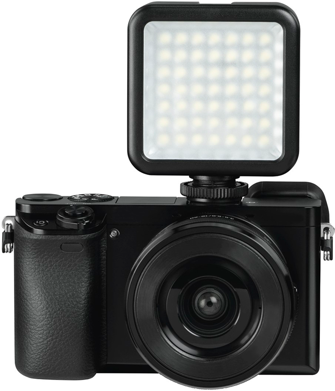 Zwarte camera met flitser bevestigd, op een witte achtergrond. De flitser is rechthoekig en zit bovenop de camera.