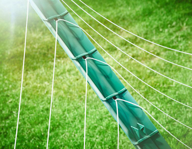 Nahaufnahme einer Ecke eines Fussballnetzes. Grünes Metall, weißes Netz und grüner Rasen im Hintergrund.