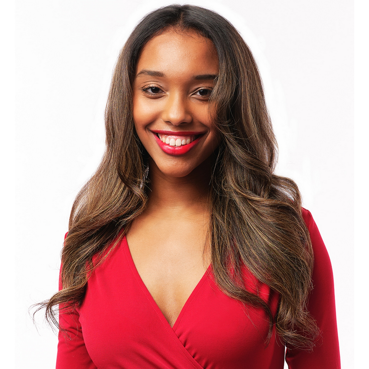 Una mujer sonriente con cabello largo y ondulado castaño y lápiz labial rojo. Lleva un vestido rojo.