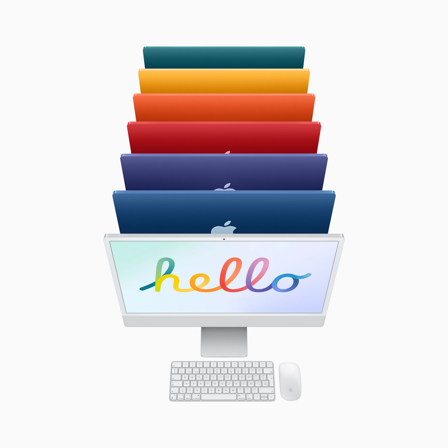 Un iMac en un escritorio blanco con teclado y ratón. Detrás, iMacs de colores apilados.
