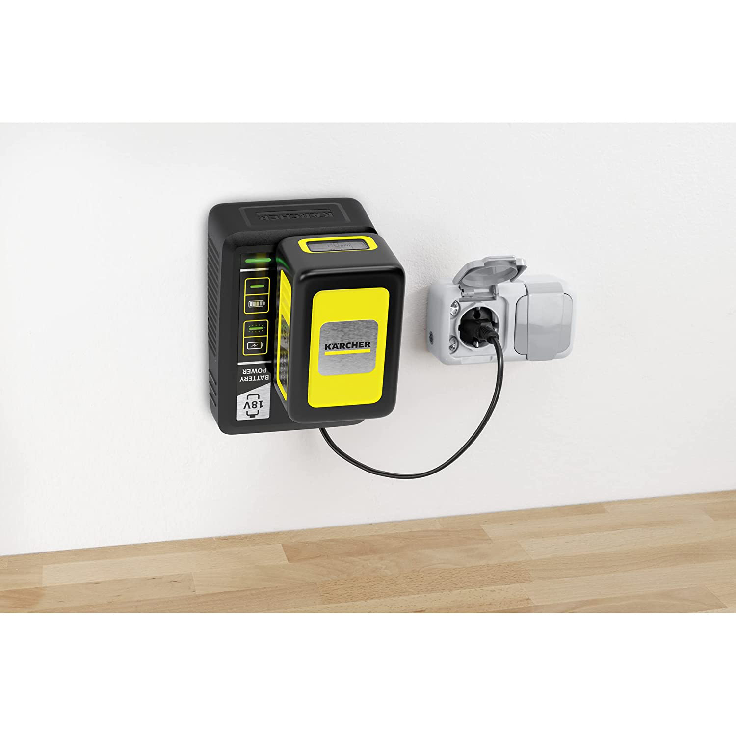 Caricabatterie da parete nero con batteria gialla e presa di corrente su superficie in legno.