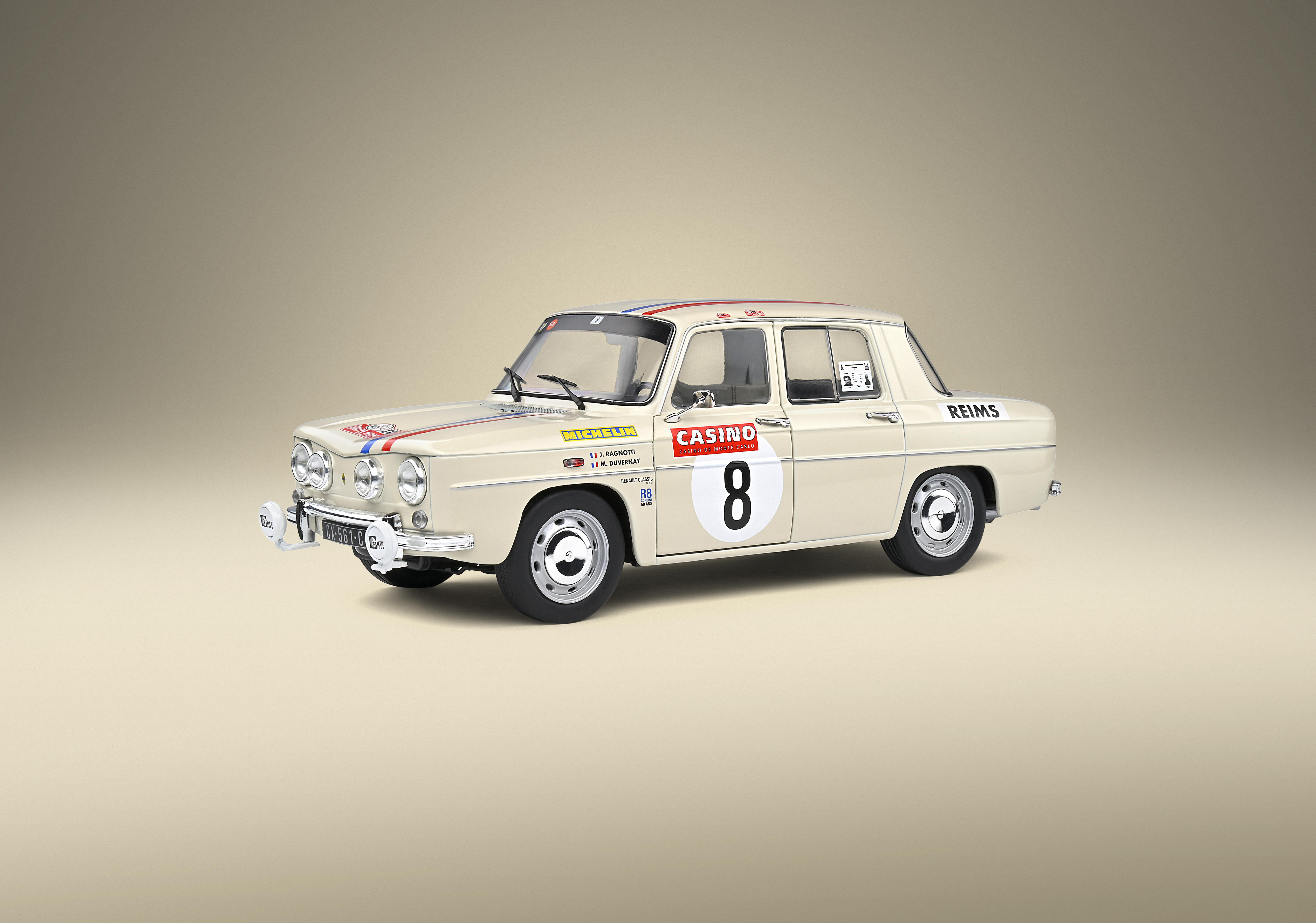 Cremefarbenes Oldtimer-Auto mit Rennaufklebern und der Nummer 8 auf der Tür.