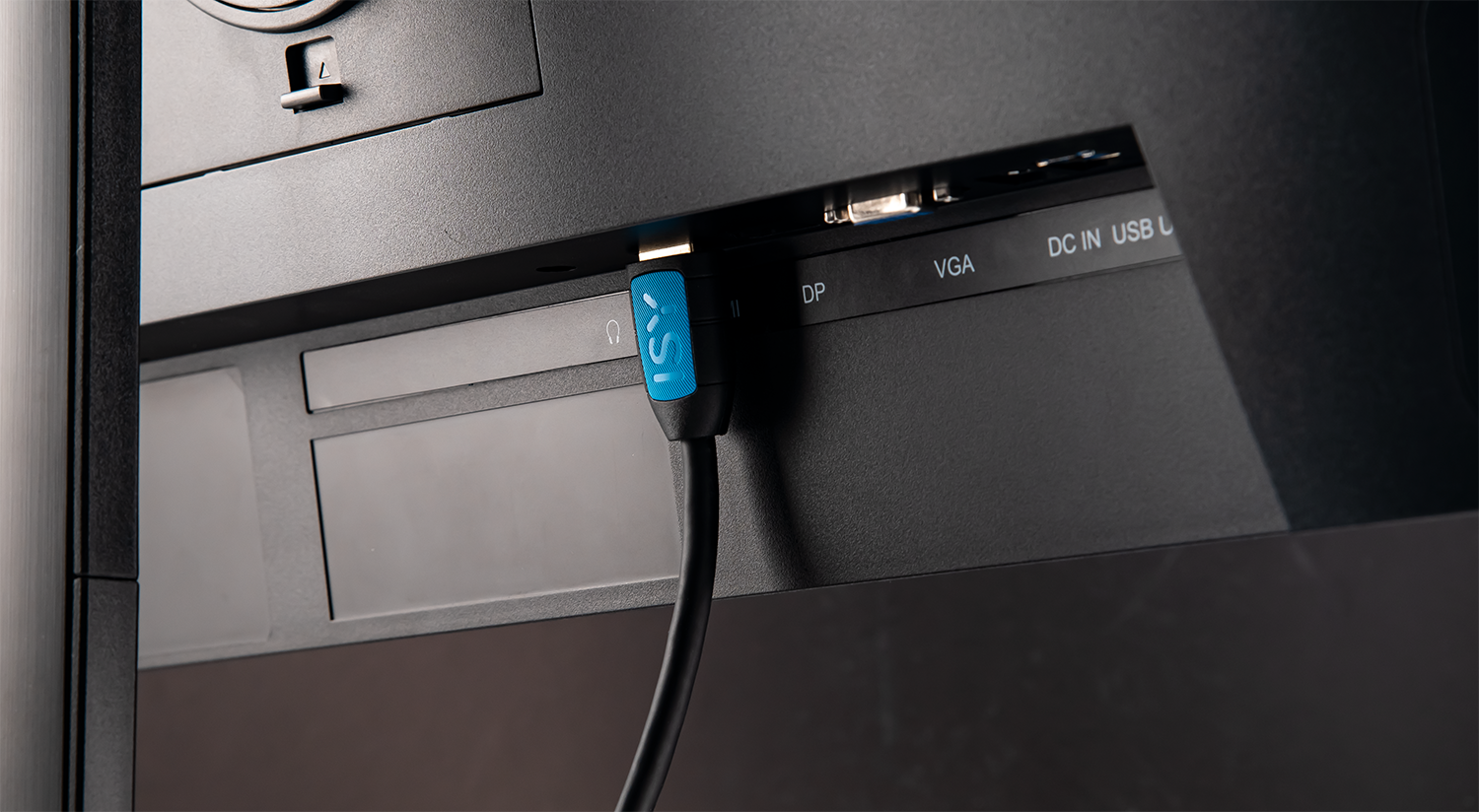 A monitor's back with cables plugged in; a blue and black cable is attached.