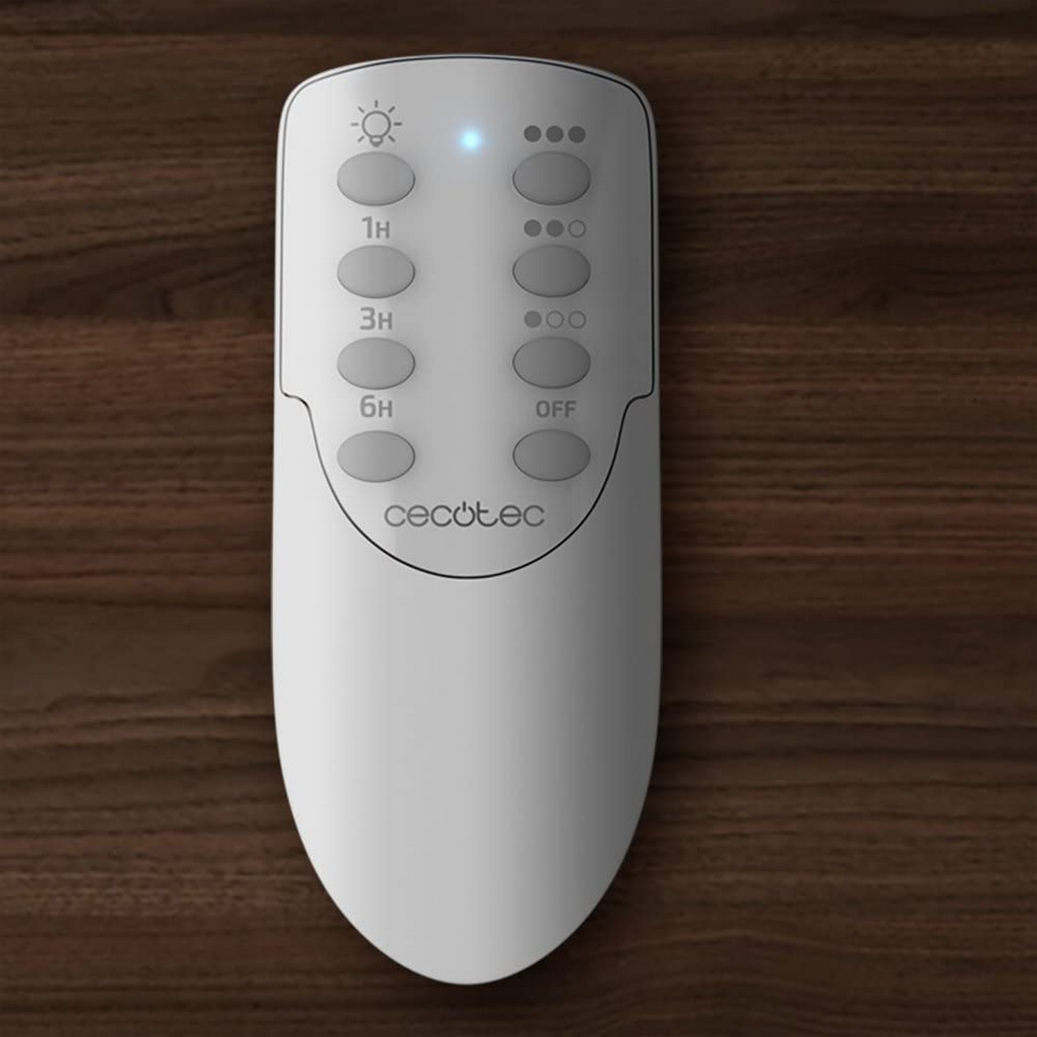 Control remoto blanco con botones, sobre madera. Botones: luz, temporizador y opciones.