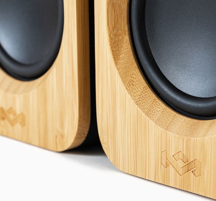 Gros plan sur deux enceintes en bois, texture bambou, avec le logo de l'entreprise visible.
