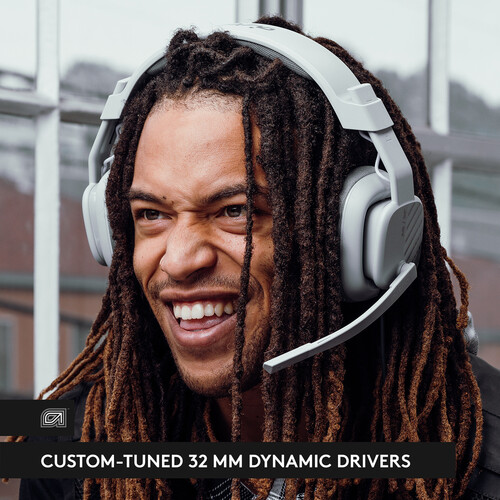 Mann mit Dreadlocks trägt graue Kopfhörer, lächelt. Text: 'Custom-tuned 32mm dynamic drivers'.