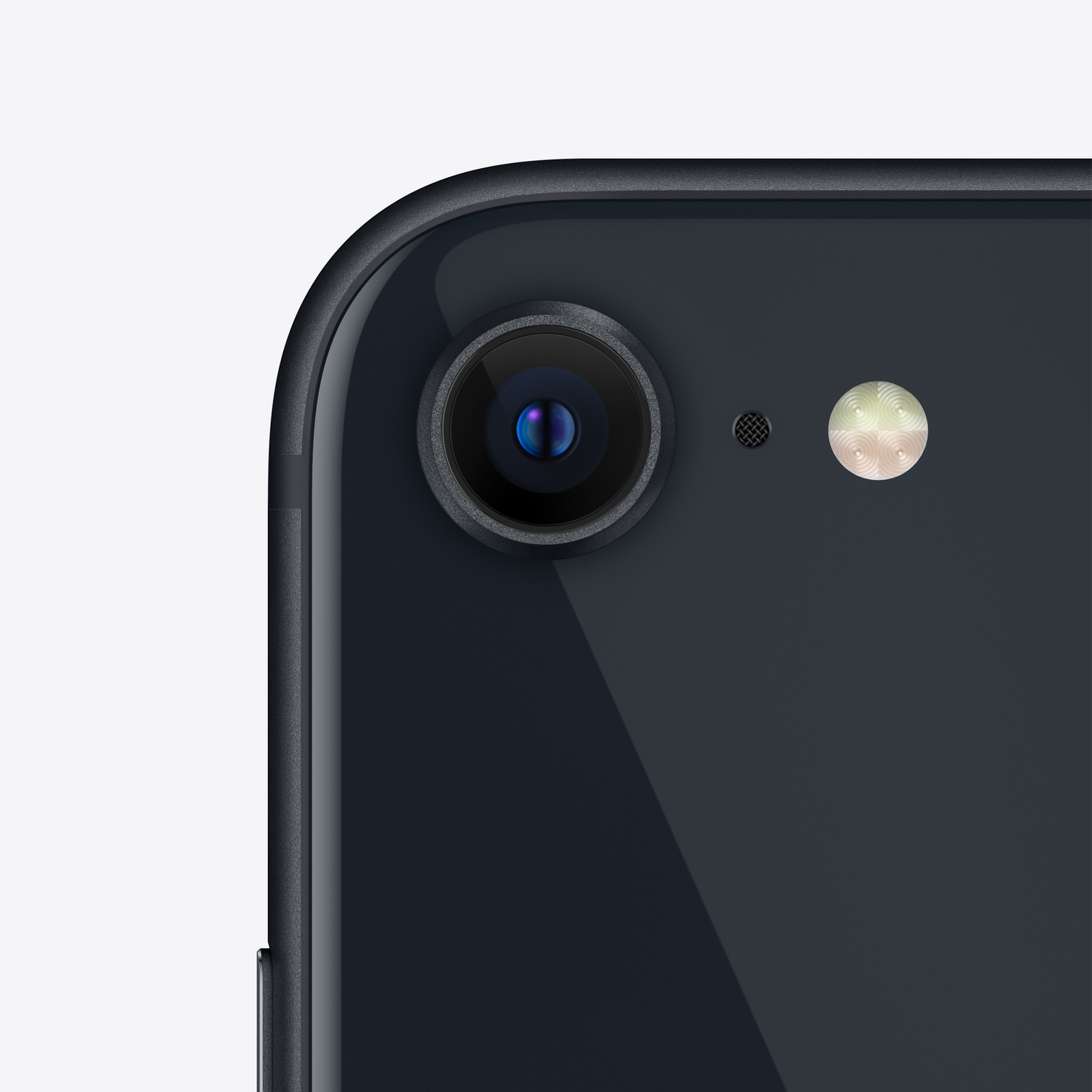 Primer plano de la lente de la cámara de un smartphone negro con flash y micrófono, sobre fondo blanco.