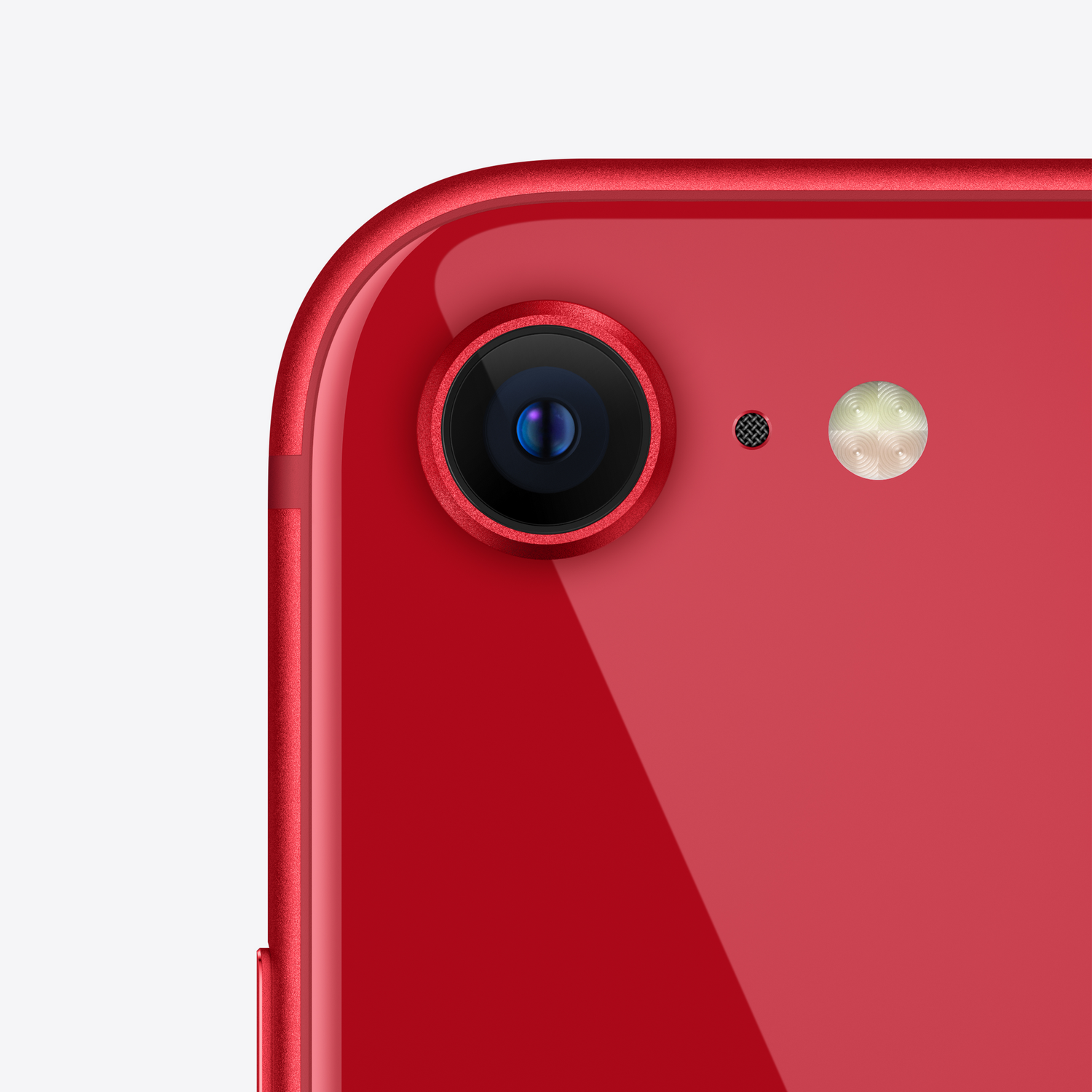 Primer plano de la lente de la cámara de un smartphone rojo con flash y micrófono, sobre fondo blanco.
