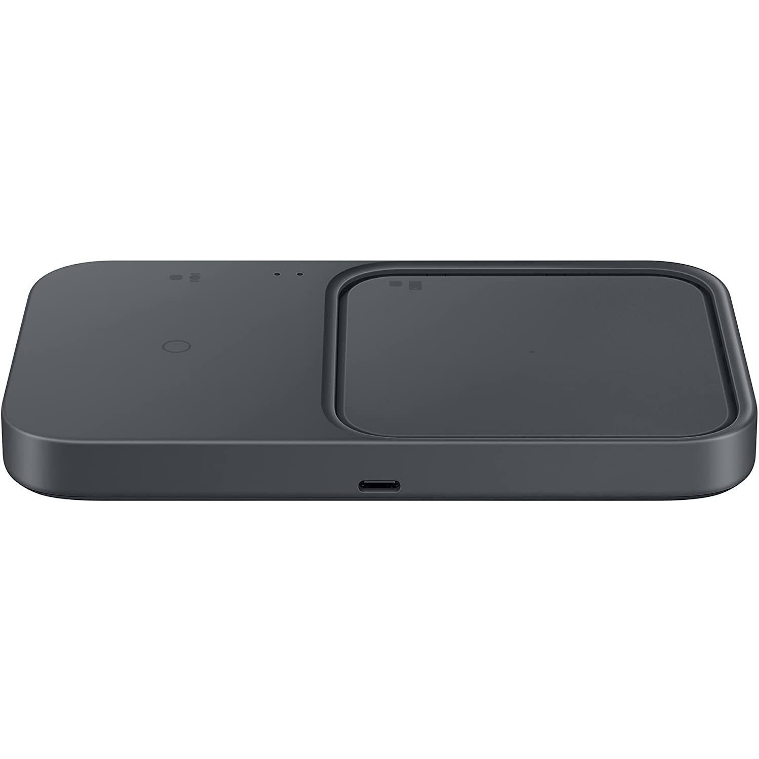 Base de carga inalámbrica negra. Rectangular con dos áreas de carga y un puerto USB-C. Superficie oscura.