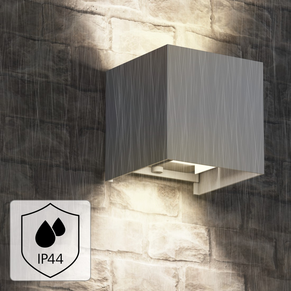 Eine graue quadratische Außenlampe an einer Ziegelmauer. Sie hat eine quadratische Form und das IP44-Logo ist vorhanden.