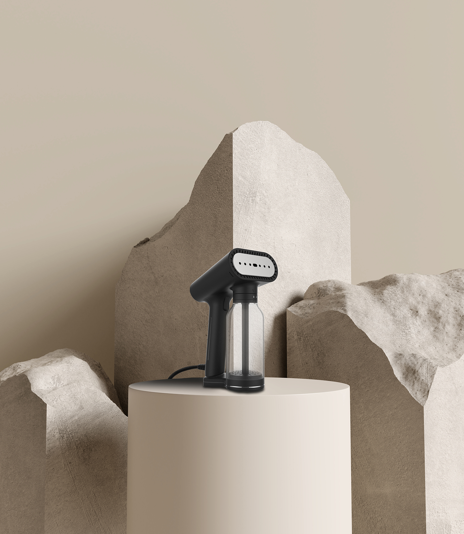 Zwarte en grijze handstomer op een witte sokkel, beige achtergrond met rotsvormen.