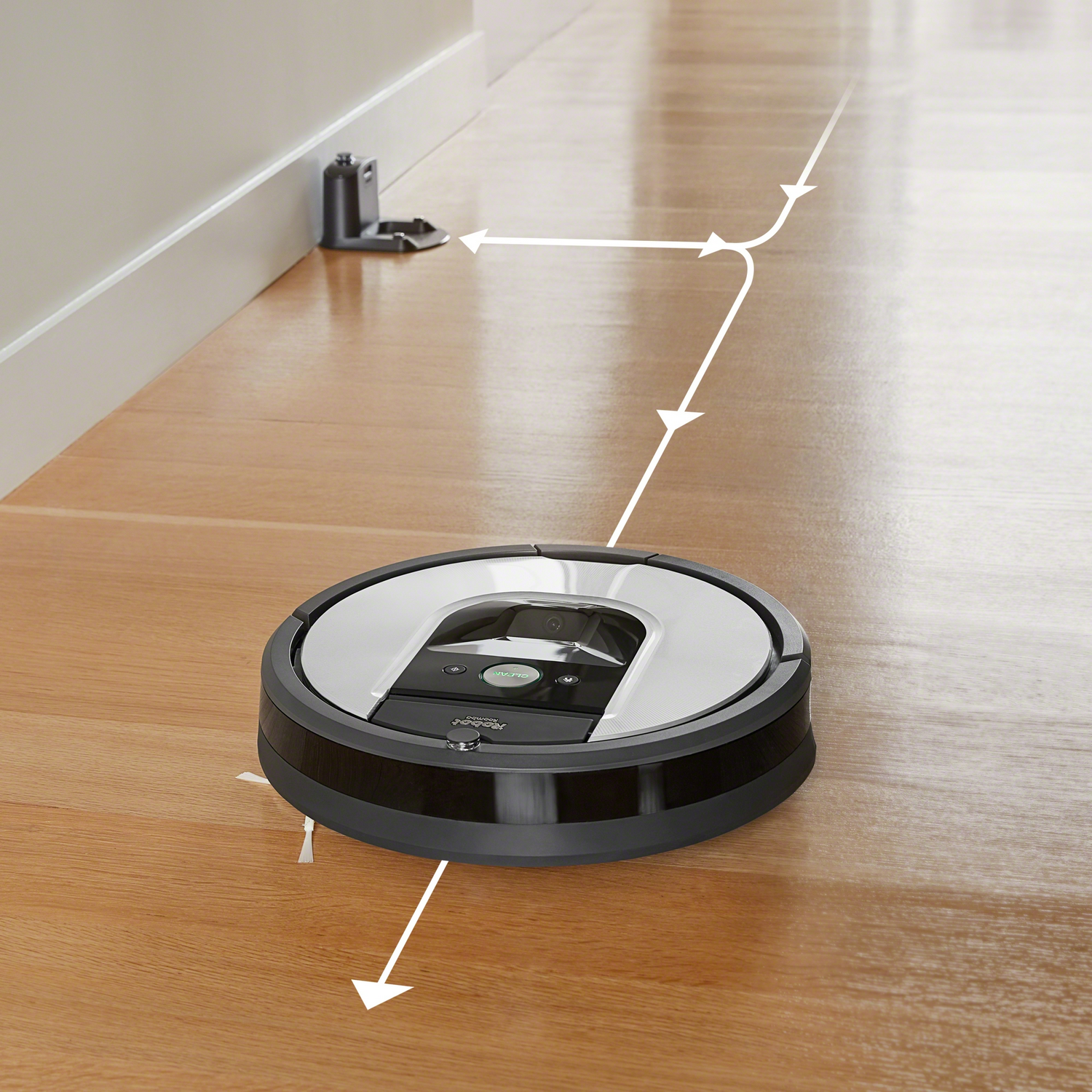 Robot aspirador en suelo de madera, camino de limpieza marcado con flechas.
