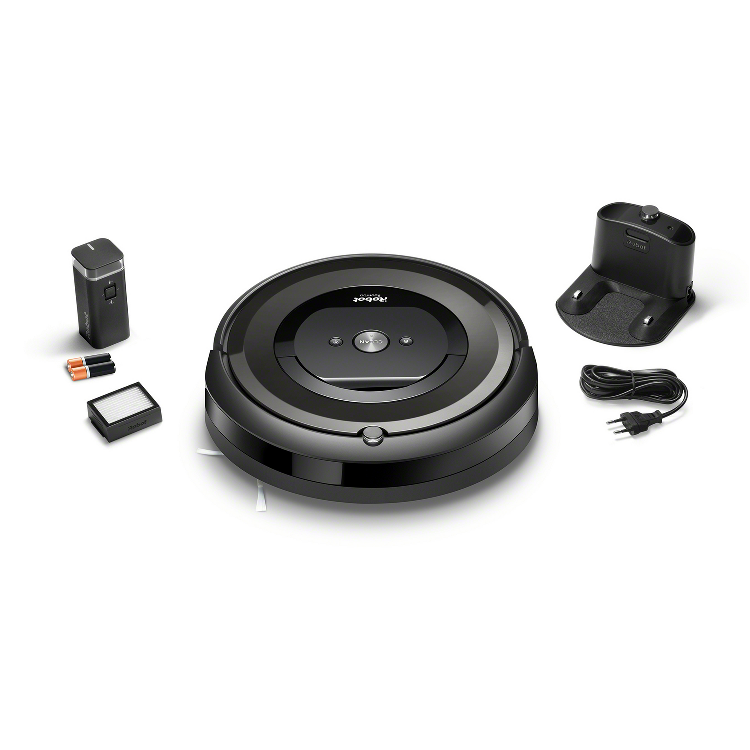 Aspiradora Roomba negra, base de carga, mando a distancia, filtro y pilas sobre fondo blanco. Cable conectado a la base.