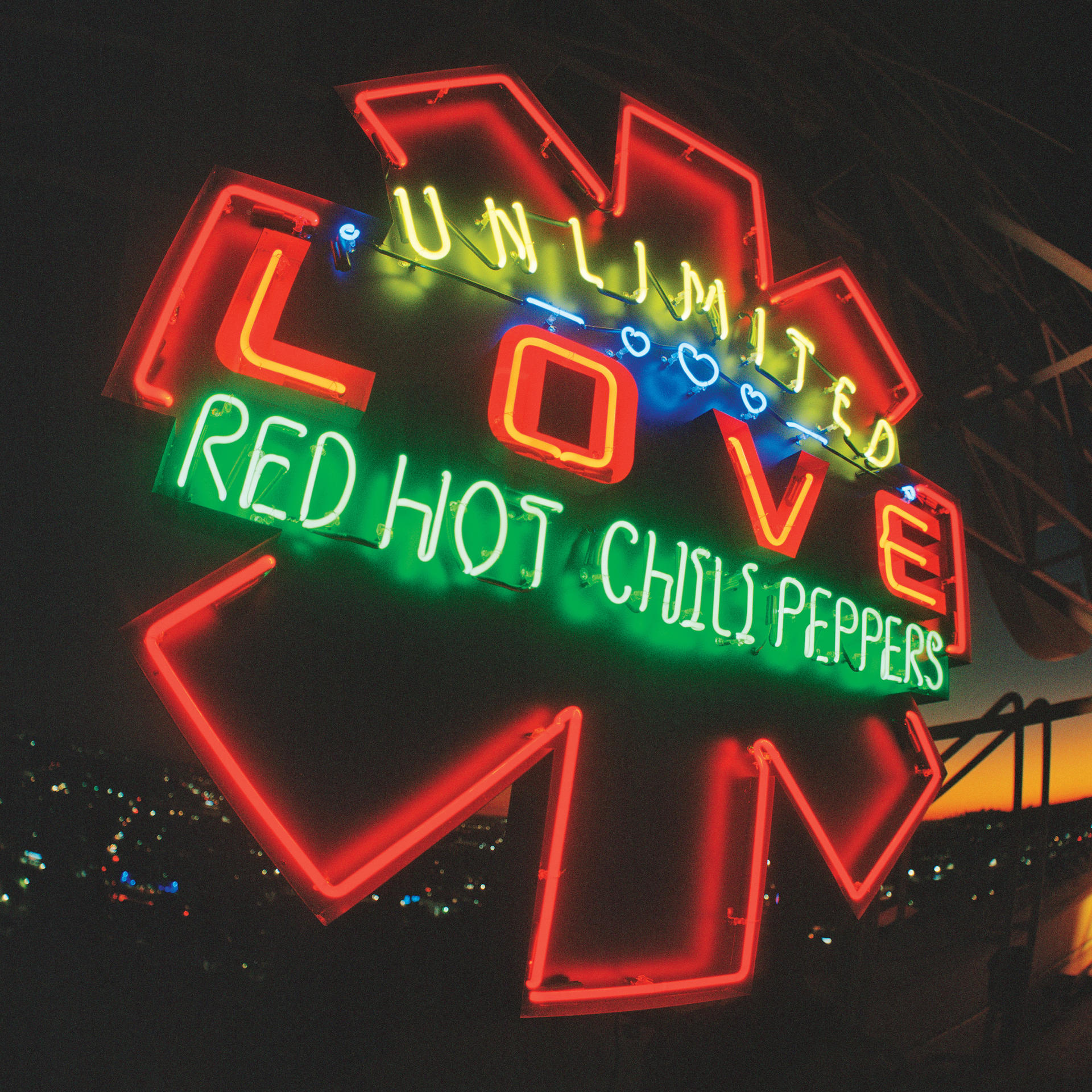 Red Hot Chili Peppers neon felirata: 'Unlimited Love' sötét, éjszakai háttérrel.