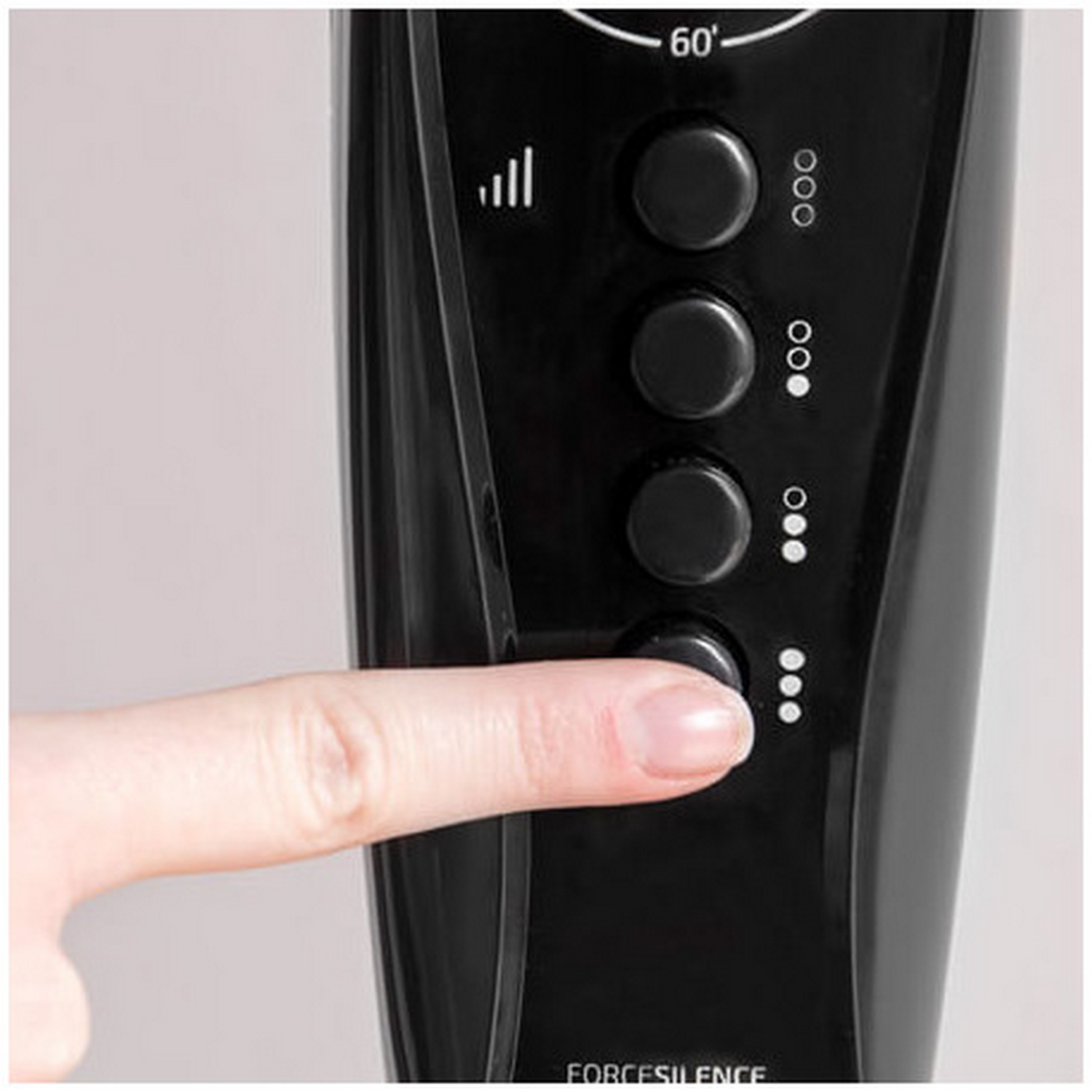 Primer plano de los botones de control del ventilador. Un dedo está pulsando el botón inferior.