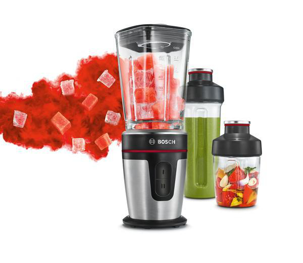 Ein silberner Mixer mit zwei weiteren Behältern mit Obst und Gemüse darin.