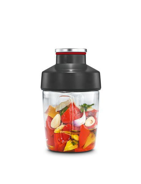 Ein klarer Behälter mit Zutaten. Rote Paprika, Knoblauch und Kräuter sind sichtbar.