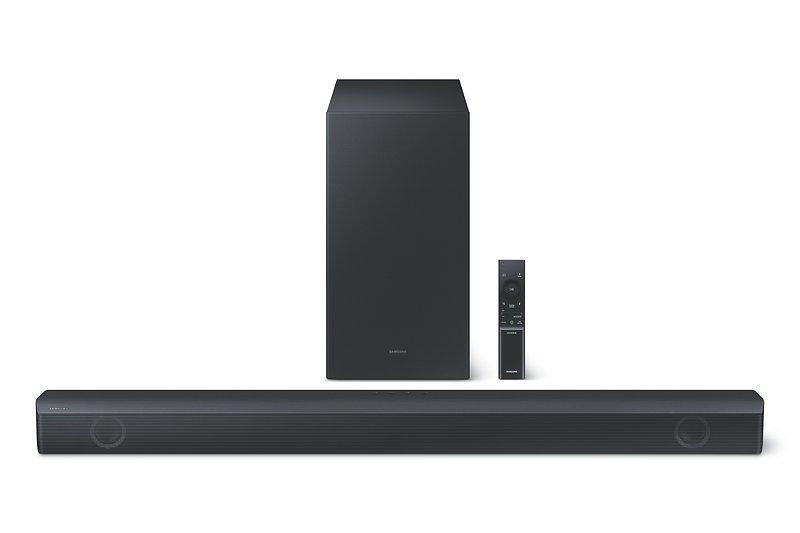 Eine schwarze Soundbar, ein Subwoofer und eine Fernbedienung auf weißem Hintergrund. Die Soundbar ist vorne.