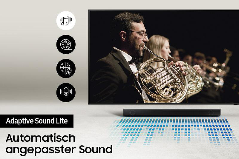 Ein Fernseher zeigt eine Live-Orchesteraufführung, begleitet von einer Soundbar und Symbolen.