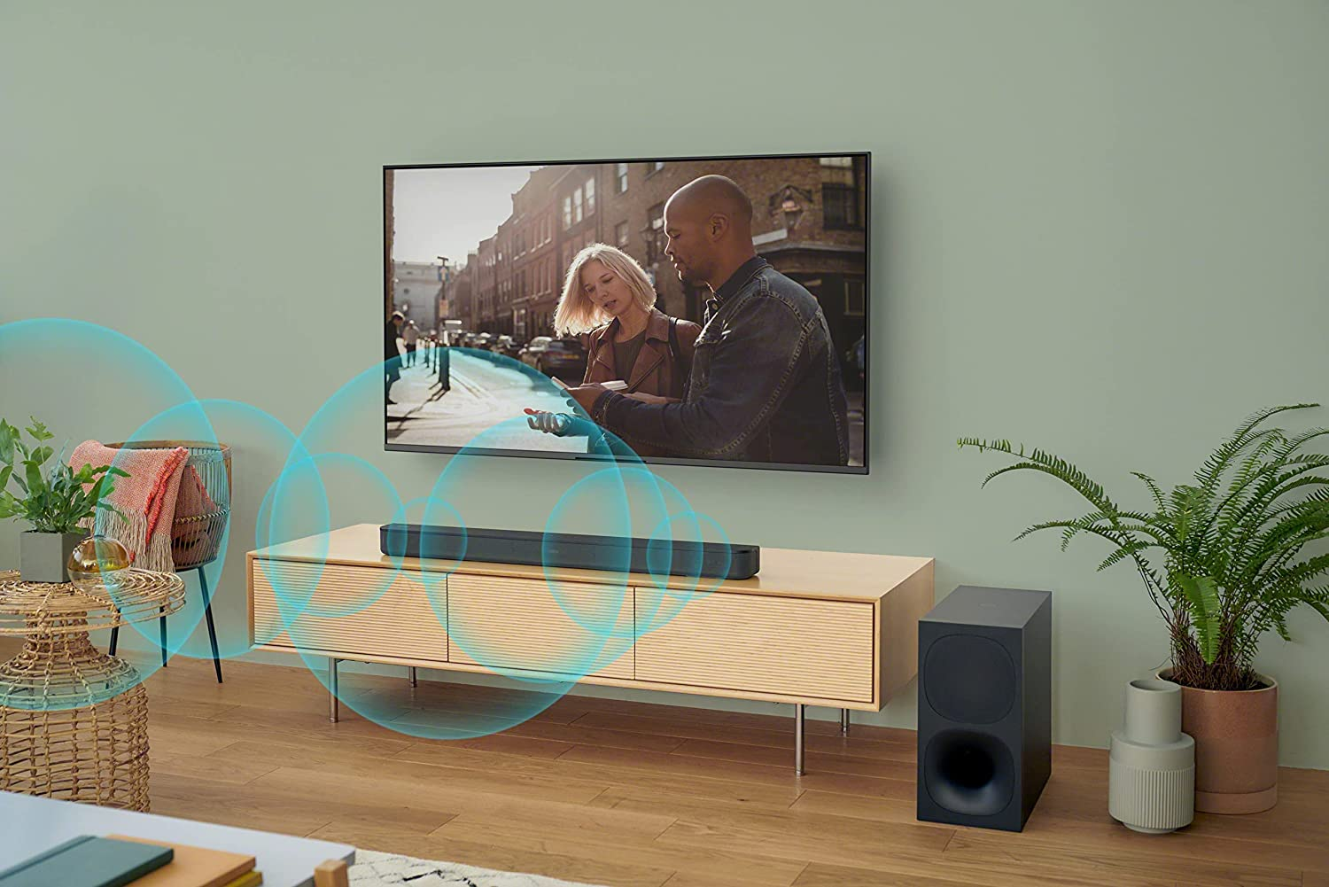 Woonkamer met tv, soundbar en subwoofer. Een stel op het tv-scherm. Geluidsgolven worden getoond.