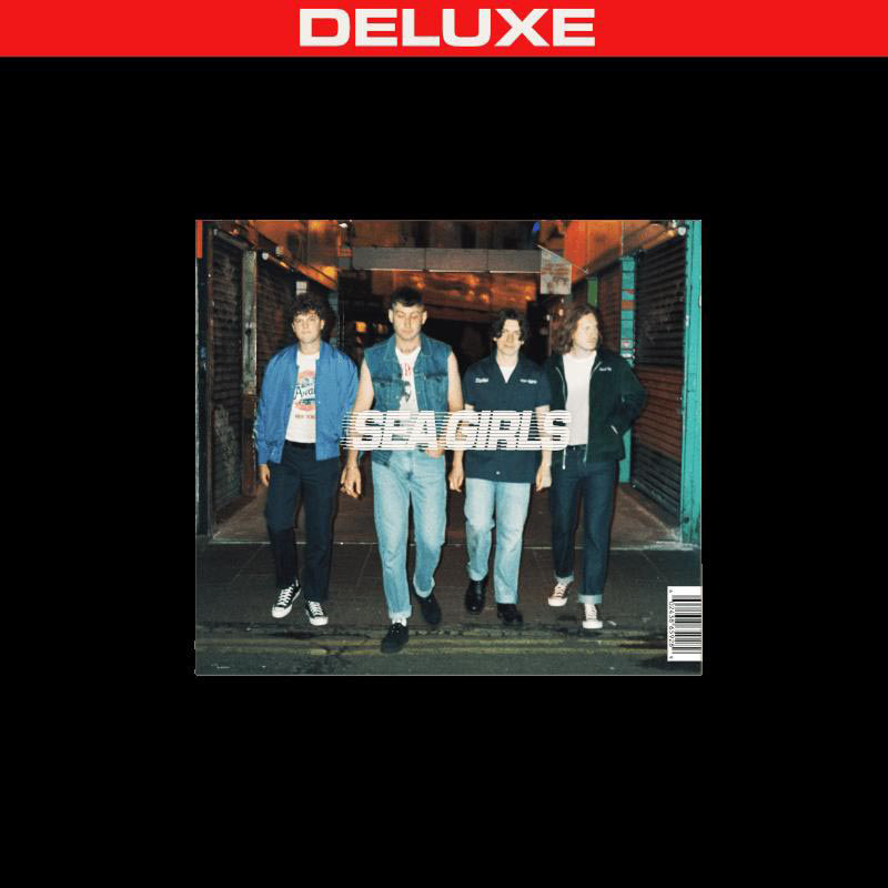 Albumcover mit vier Männern, die eine dunkle Gasse hinuntergehen. Der Text DELUXE und SEA GIRLS ist sichtbar.