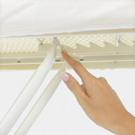 Close-up of an ironing board. A hand touches the support mechanism.